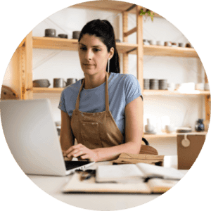 Small business owner working on a laptop in her pottery studio